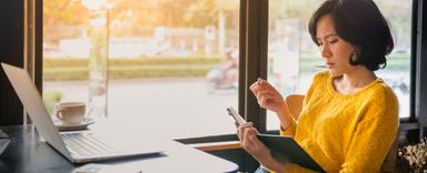 woman looking at her planner in a cafe