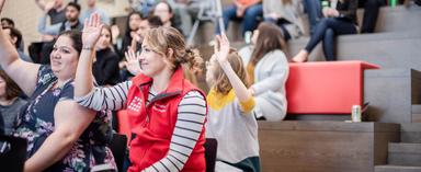 LendingClub employees raising their hands at all team meeting